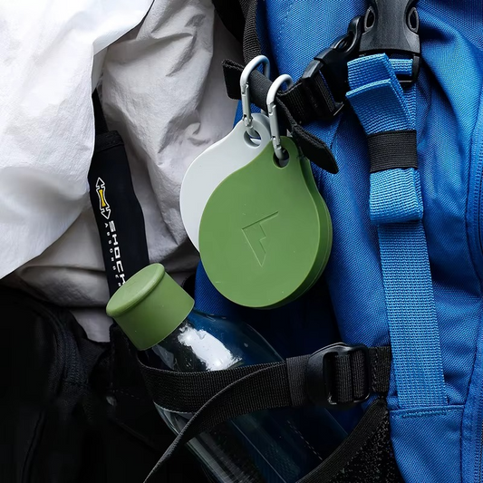 The GoCup™ - Collapsible Travel Mug clipped to a backpack, highlighting its portability and convenience for travel and outdoor adventures.