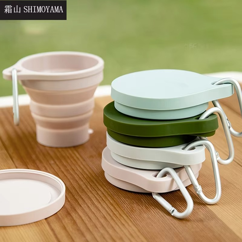 Stacked The GoCup™ - Collapsible Travel Mugs in pastel colors with carabiners, emphasizing compact storage and reusable silicone material.