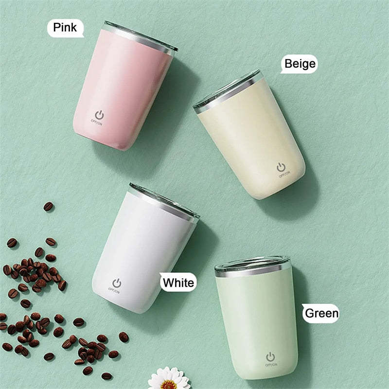Top view of AutoMug Pro™ cups in four pastel colors on green surface with coffee beans