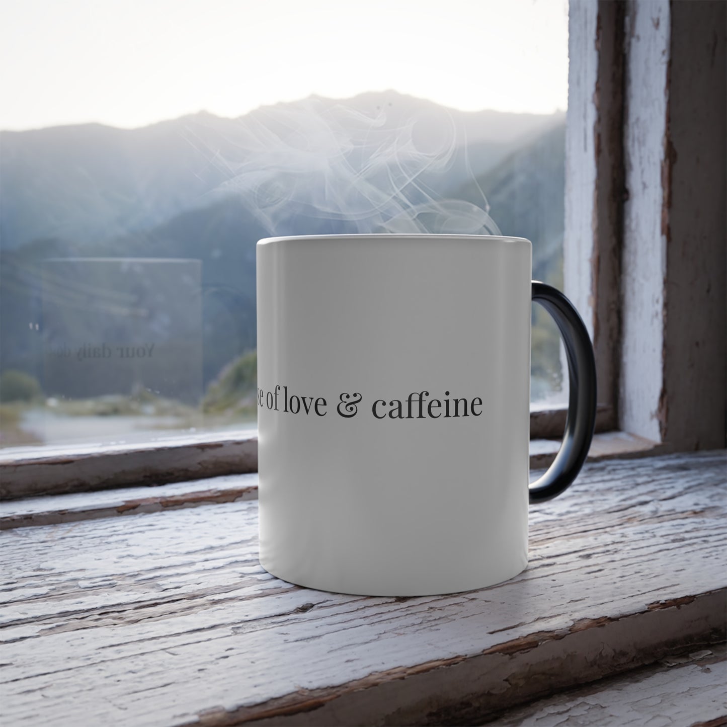 Thermal reveal mug showing 'Your daily dose of love & caffeine' with scenic mountain view
