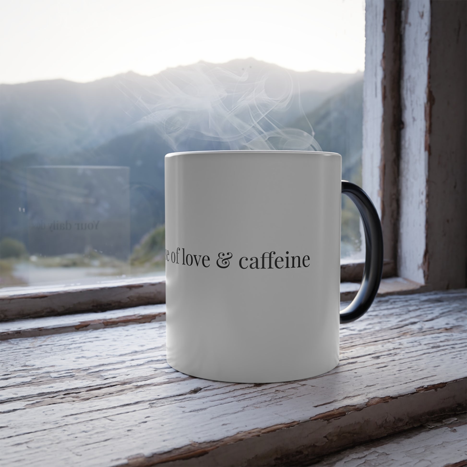 Thermal reveal mug showing 'Your daily dose of love & caffeine' with scenic mountain view